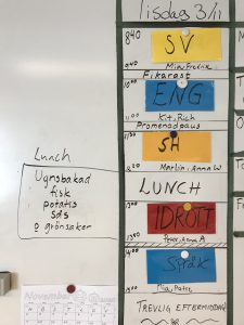 Foto på en whiteboard där man skrivit upp schema för dagen och maten som serveras i matsalen.